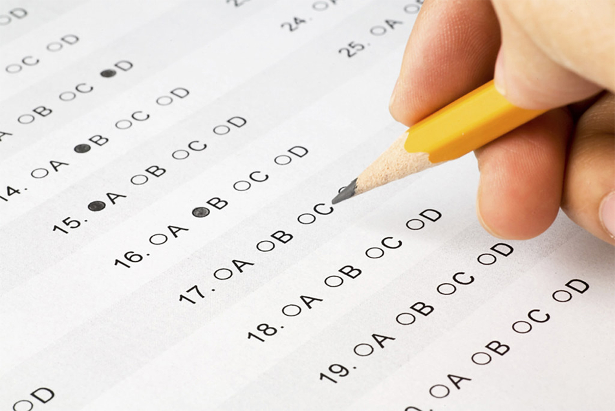 Hand completing a school exam