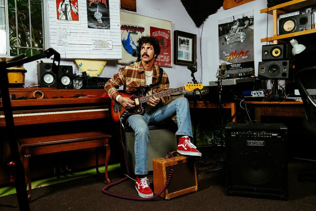 Josh Landau with a Jaguar guitar, wearing Brixton's Jaguar clothing collection