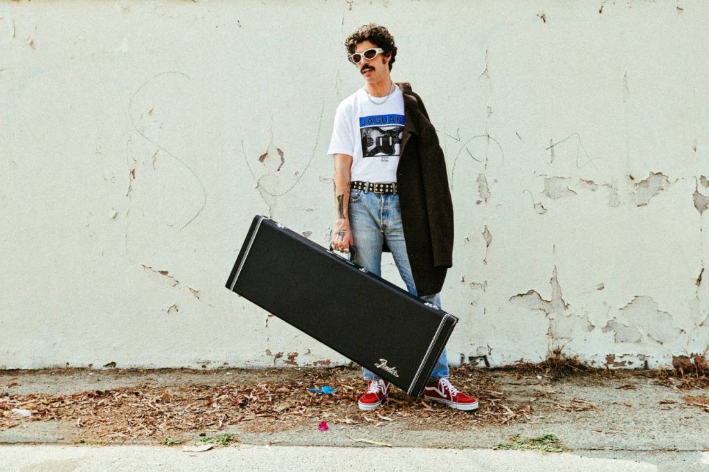 Josh Landau with a Jaguar guitar, wearing Brixton's Jaguar clothing collection